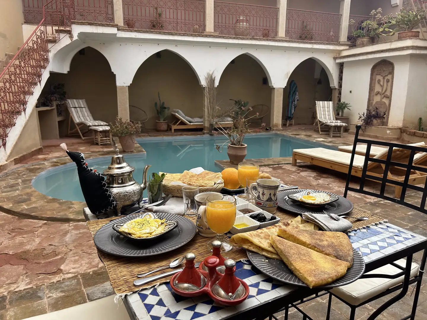 Petit-déjeuner dressé au bord de la piscine du Riad Dar Laure
