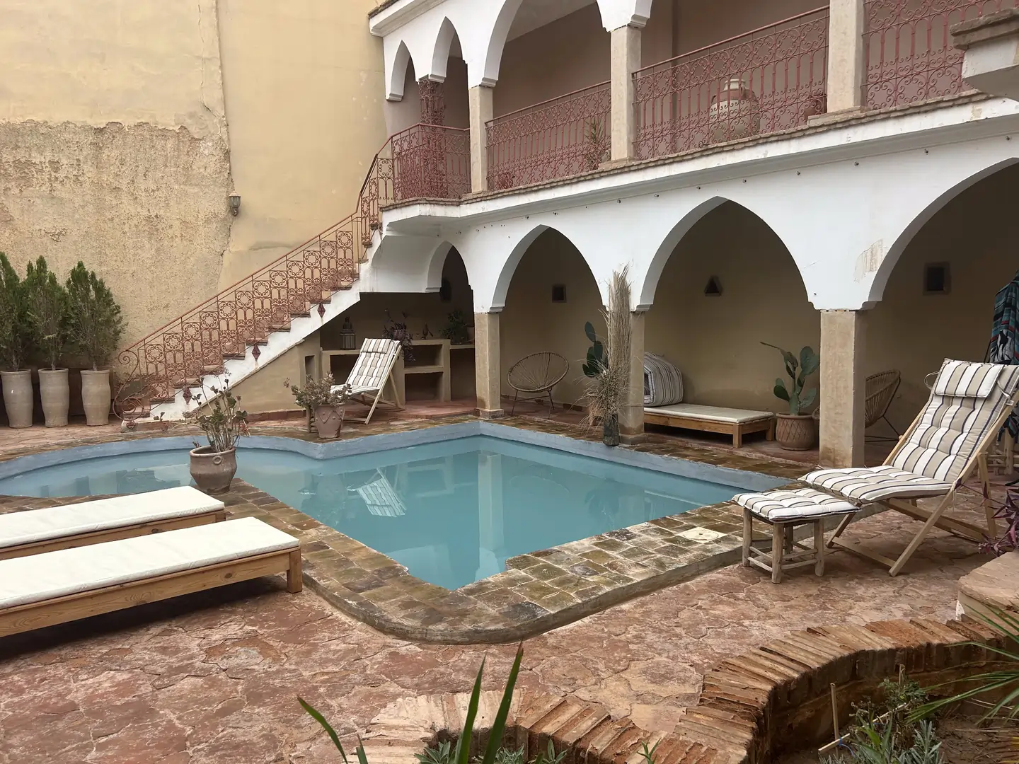Piscine du riad entourée d’arches marocaines