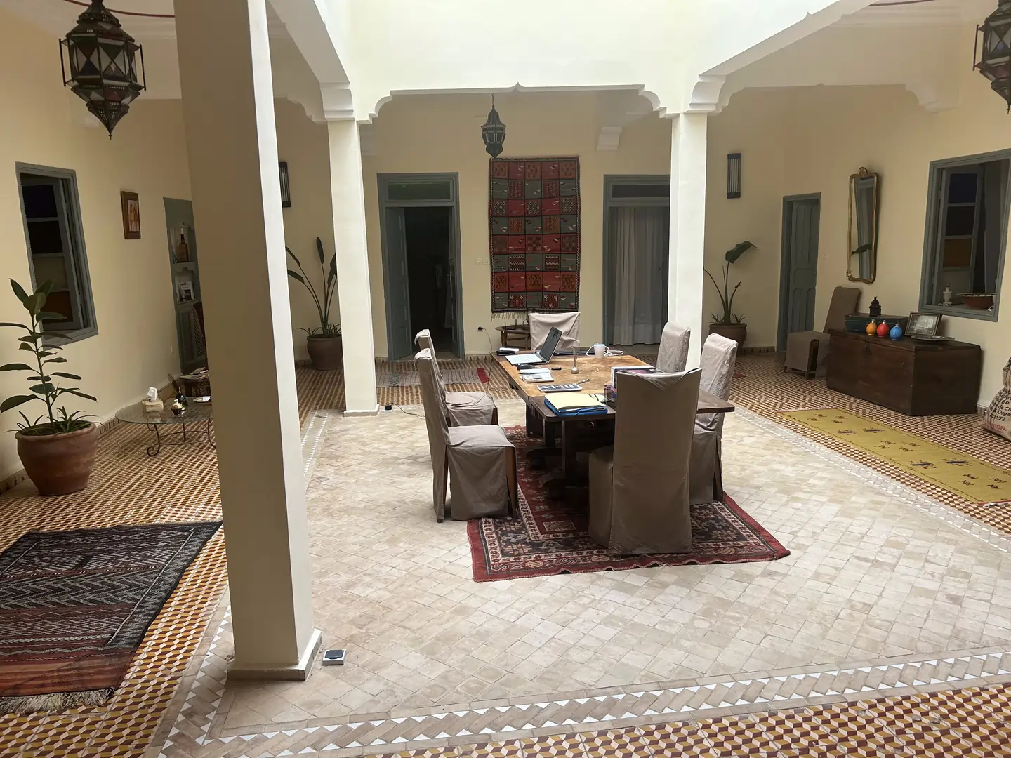 Grande cour intérieure avec table et tapis marocains